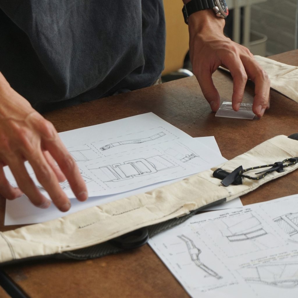 a designer references a sketch of a buckle while prototyping