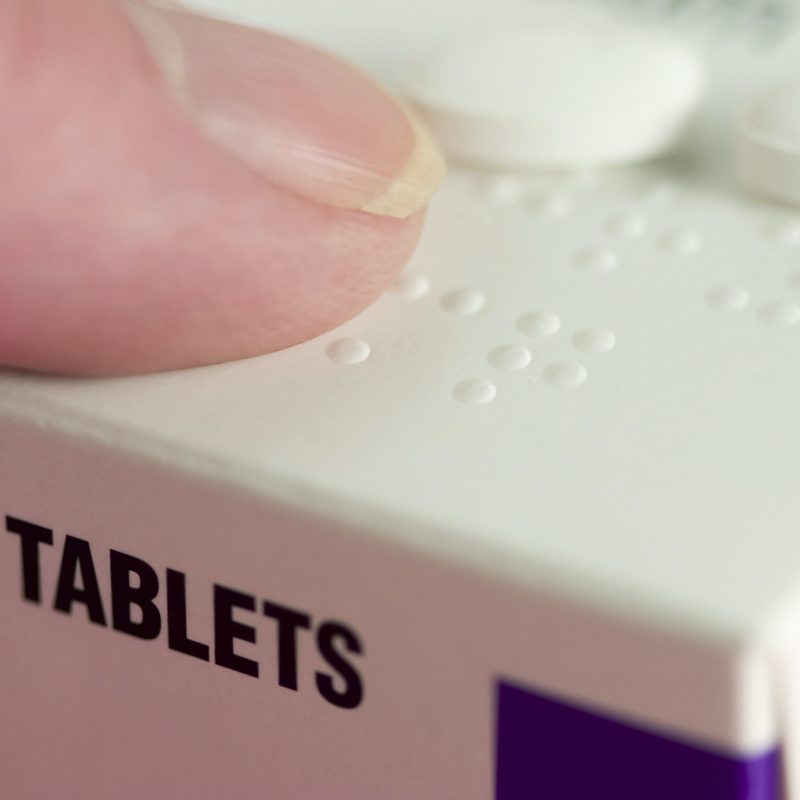 Reading Braille on a medication carton